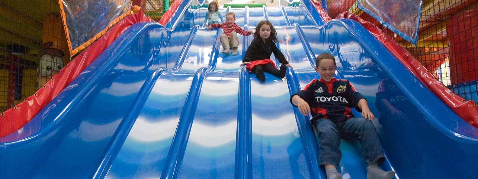 Children enjoying the blue slides at Monkey Maze